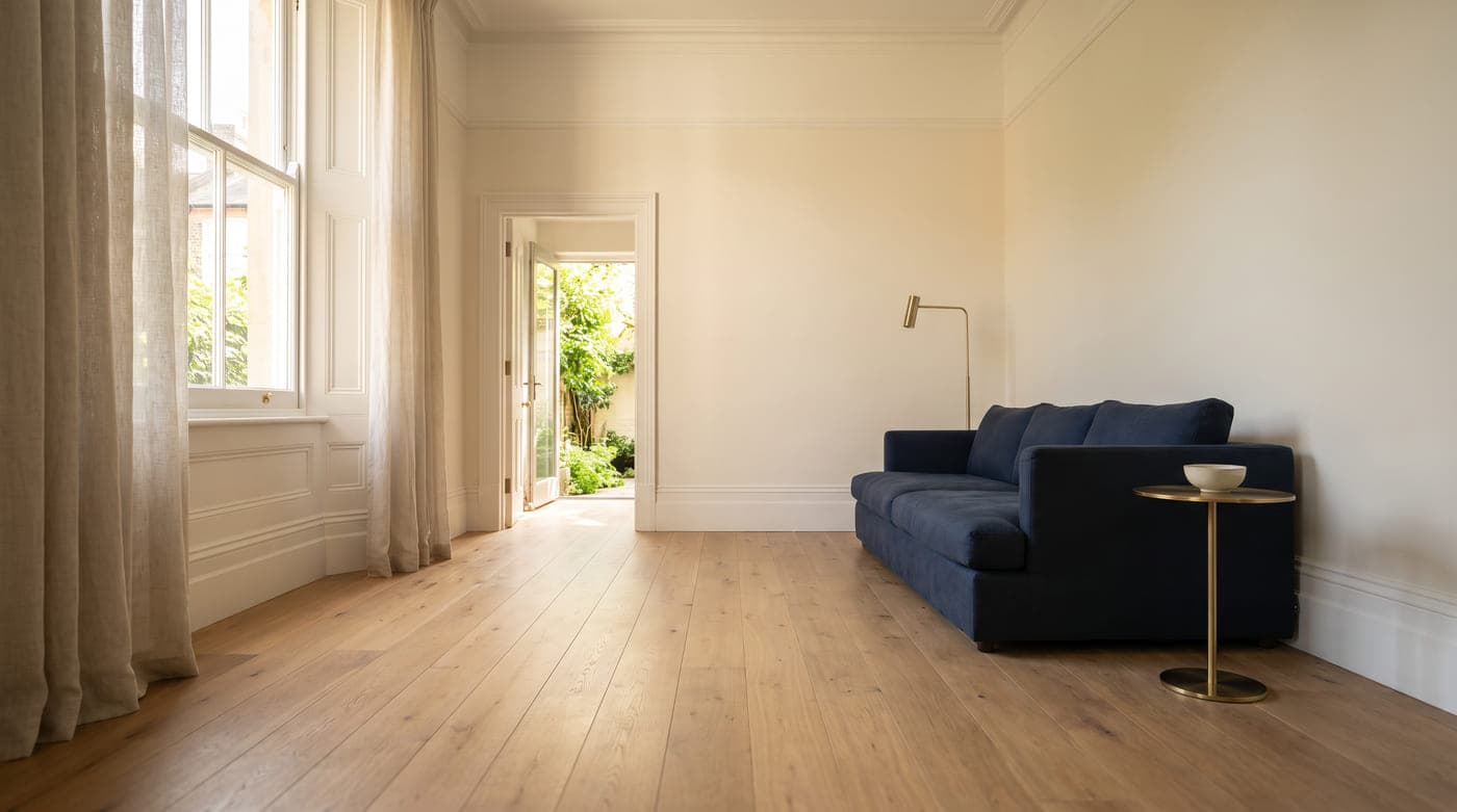 Contemporary Sydney terrace living room with wide-plank European oak flooring, a navy linen sofa and warm afternoon daylight