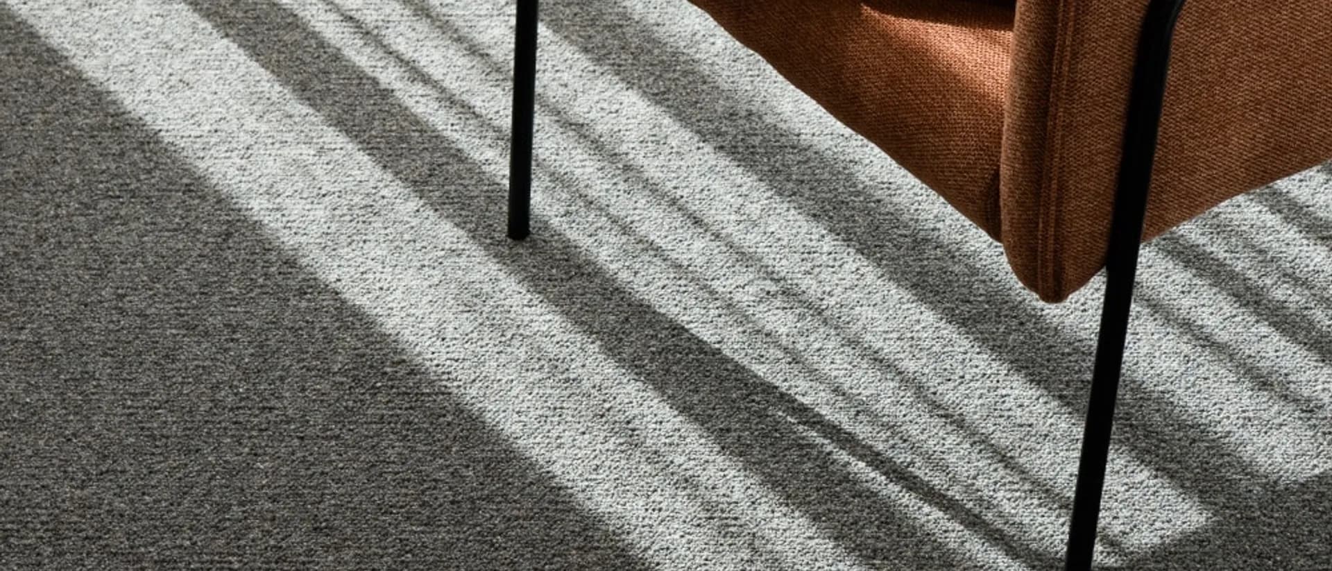 Sirocco — rust armchair by sheer curtain, sunlight across carpet