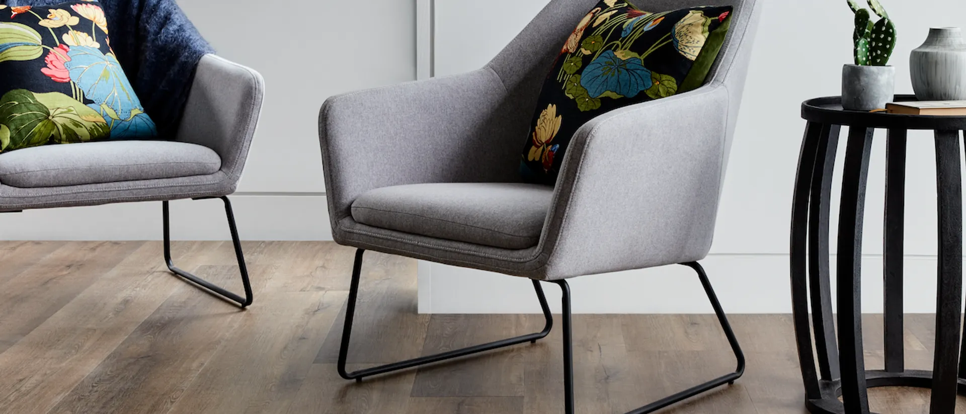 Iconic WPC — lounge chairs on grey-brown plank, artwork behind
