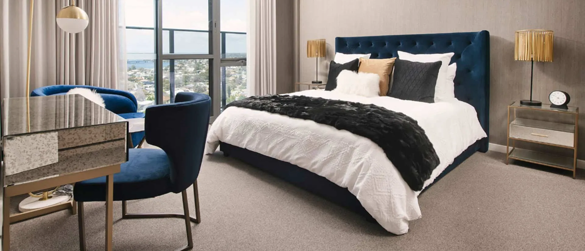 Birdwood — hotel bedroom, blue velvet bed, city view windows