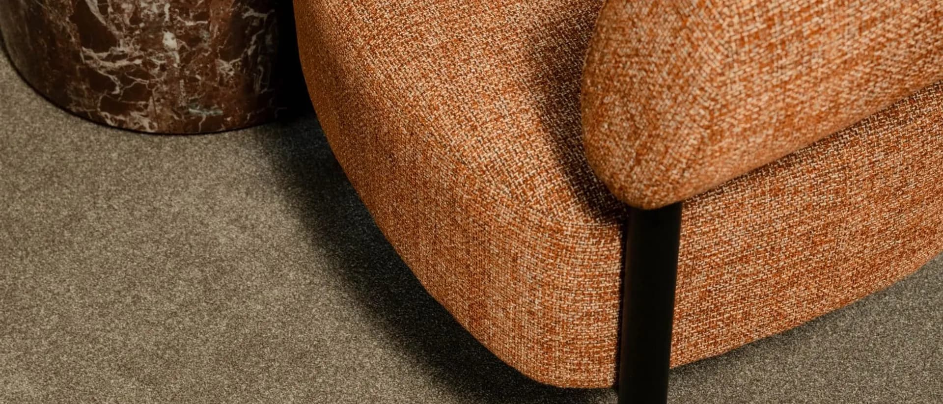 Coco Bliss — orange upholstered armchair beside burgundy marble side table