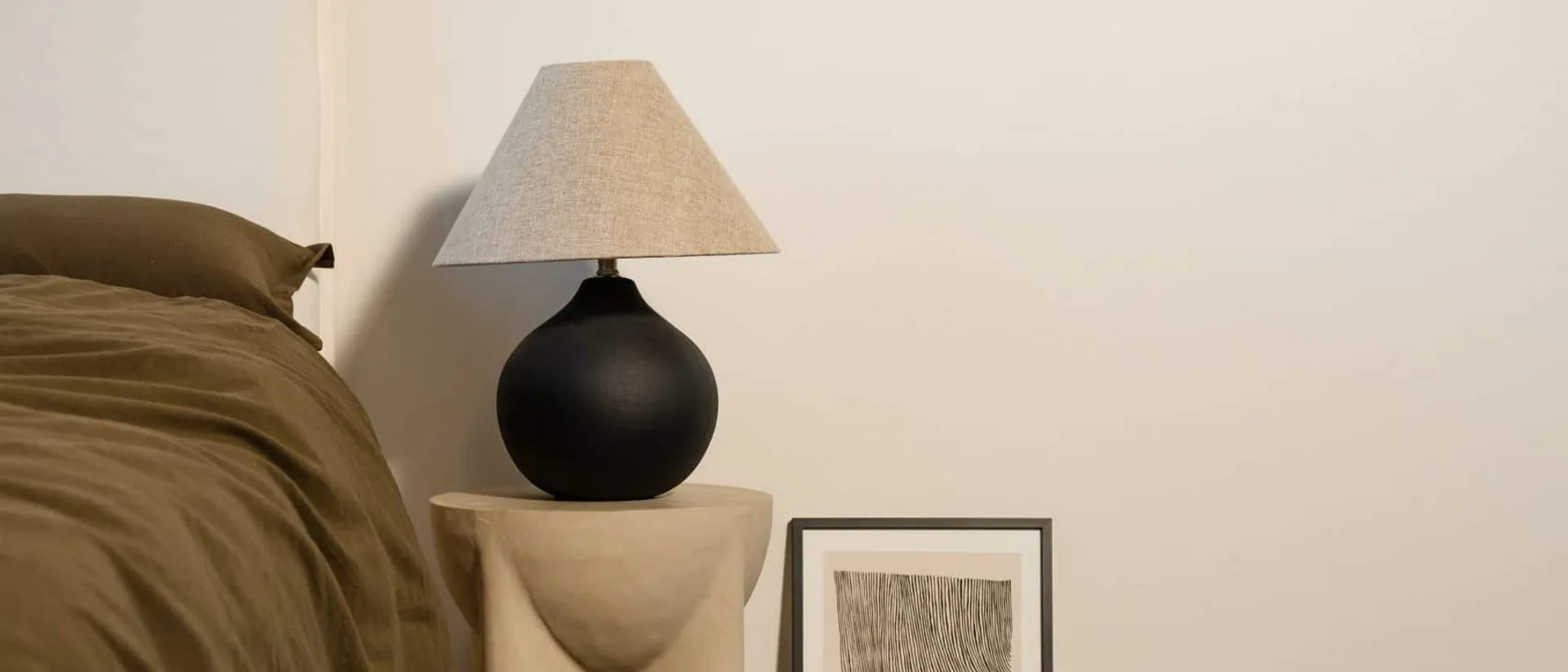 Sky Bridge — bedroom, olive bedding, lamp on plinth, framed art