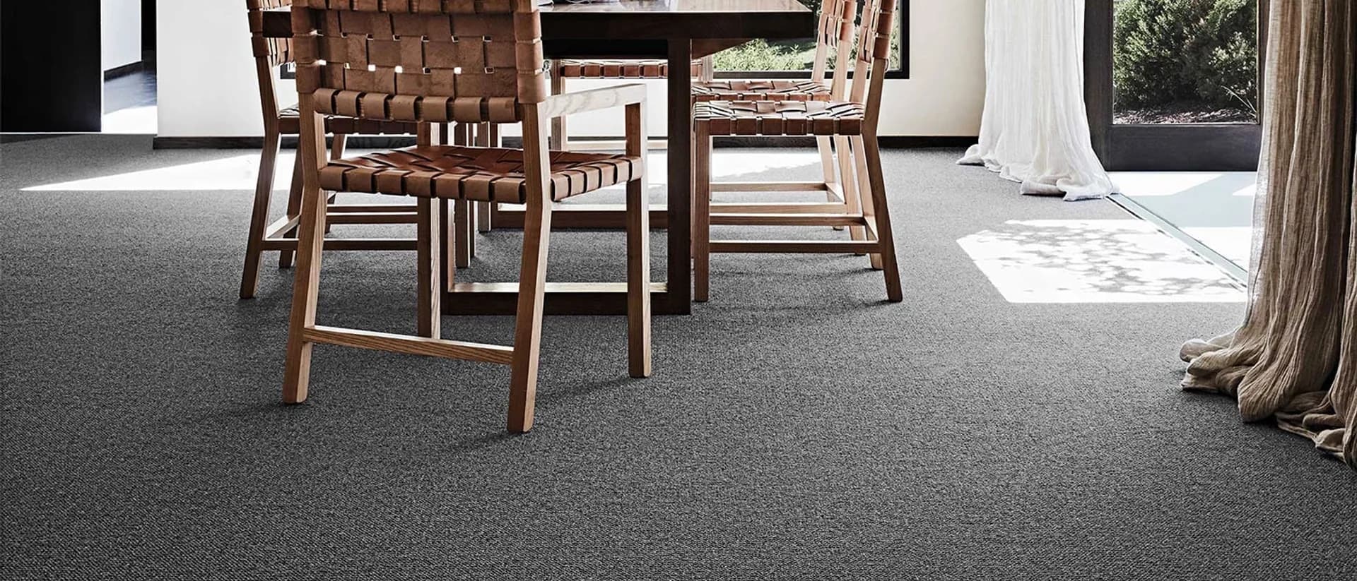 Carramar 4M — dining table beside glass doors, charcoal loop carpet