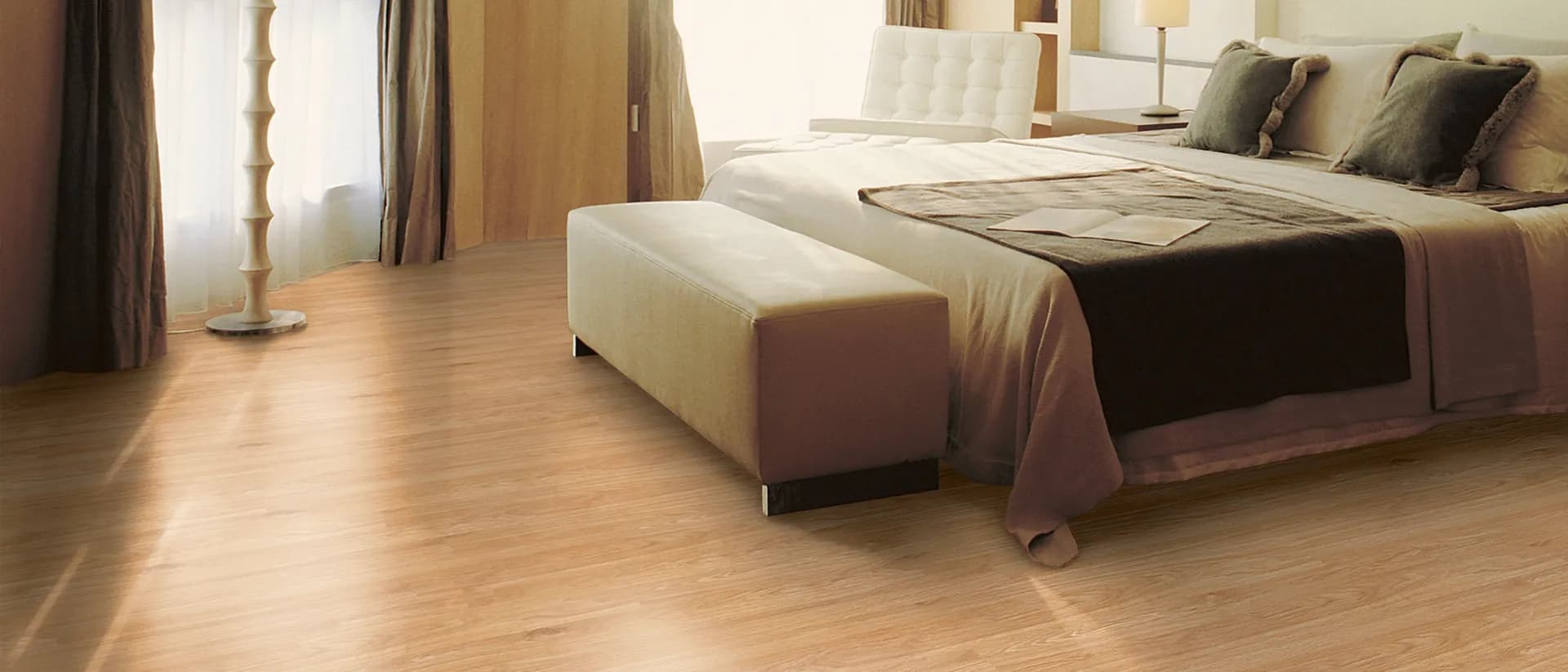 Studioflor — sunlit bedroom, sheer curtains, warm natural plank floor