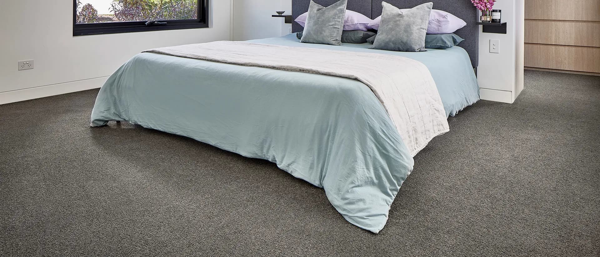 Skyway — bedroom with pale blue bedding on charcoal carpet